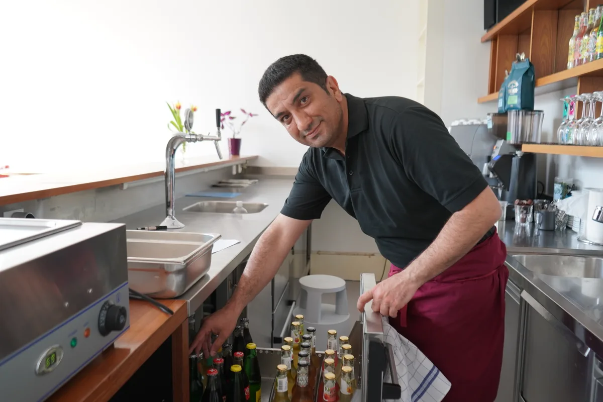 Hamid Reza aus dem Iran prüft das getränkesortiment.